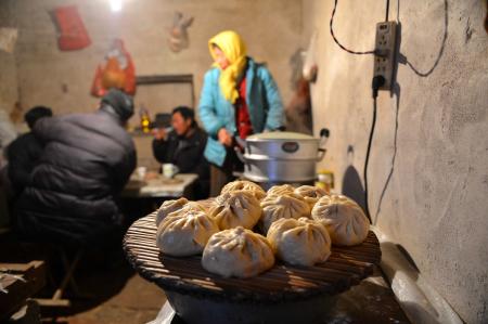  結束一天勞作的“葦客”準備吃晚飯（12月9日攝）。